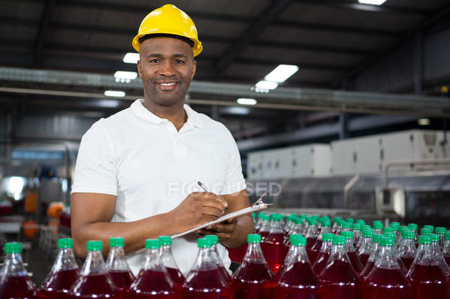 Portrait of young male worker noting in juice factory — Stock Photo