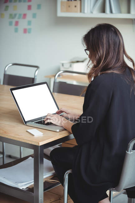 Business executive using laptop in office — Stock Photo