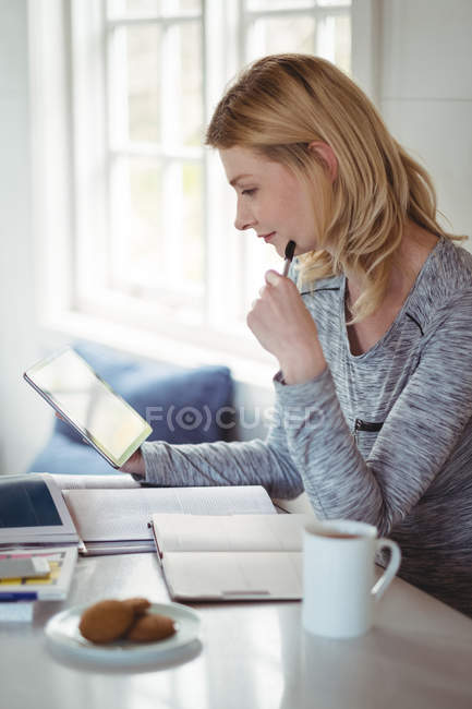 Beautiful woman using digital tablet in living room at home — Stock Photo