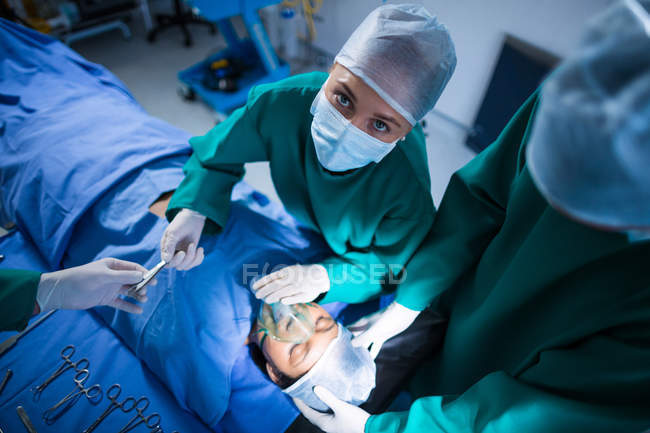 Cirurgiões que realizam operação no teatro de operação do hospital — Fotografia de Stock