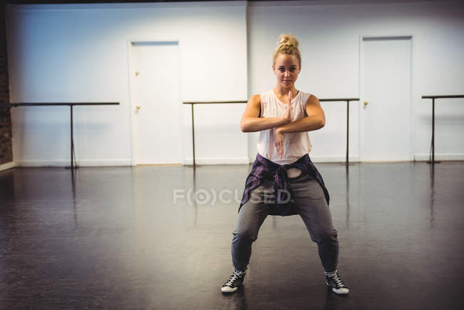 Femme pratiquant un mouvement de danse en studio de danse — Photo de stock