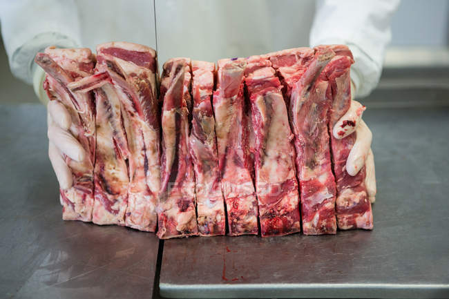 М'ясник ріже м'ясо на м'ясному заводі — стокове фото