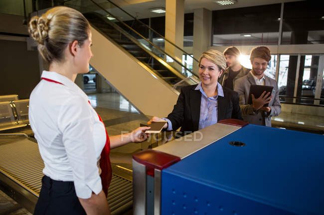 Empresária em fila recebendo passaporte e cartão de embarque no terminal do aeroporto — Fotografia de Stock