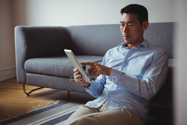 Людина використовує цифровий планшет у вітальні вдома — стокове фото
