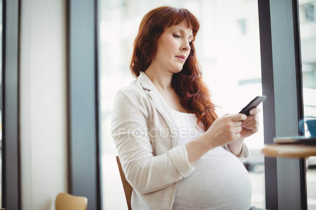 Schwangere Geschäftsfrau benutzt Handy in Büro-Cafeteria — Stockfoto