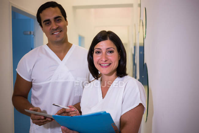 Dentista discutindo relatório com paciente do sexo feminino na clínica odontológica — Fotografia de Stock