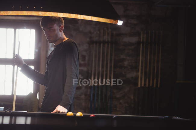 Boy standing besides pool table in the bar — Stock Photo