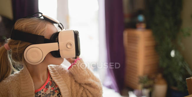 Девушка сидит с помощью гарнитуры виртуальной недвижимости дома — стоковое фото