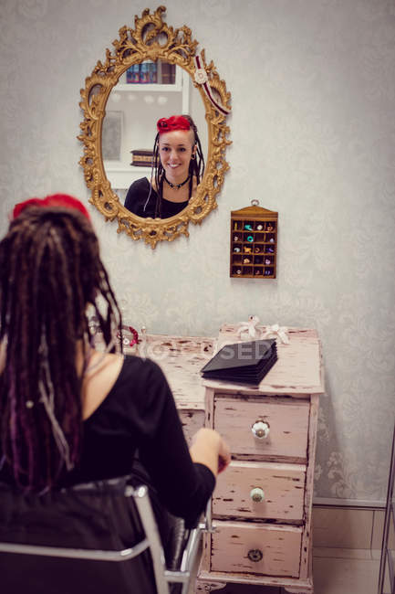 Женщина-парикмахер сидит в магазине дредов — стоковое фото