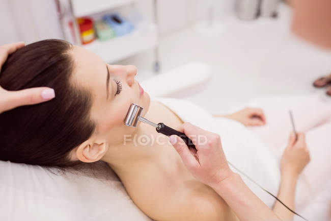 Dermatologue effectuant l'épilation au laser sur le visage du patient en clinique — Photo de stock