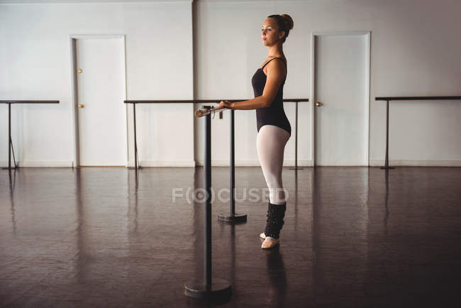 Bailarina pensativa de pie en el estudio de ballet - foto de stock