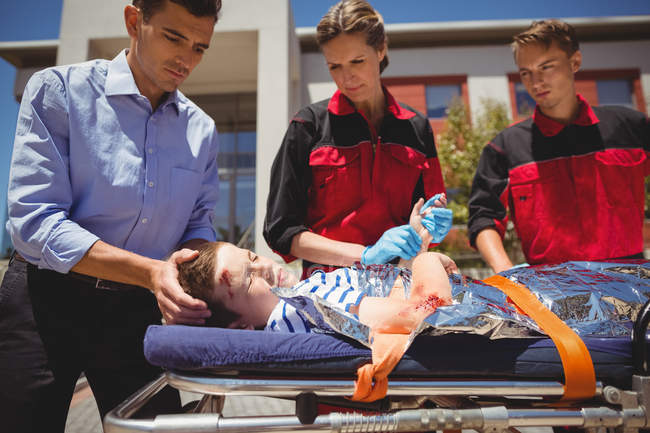 Paramedics rushing a patient in emergency on street — Stock Photo