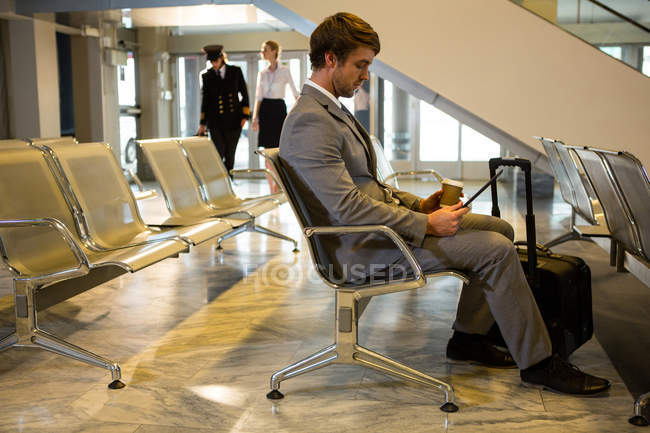 Empresário usando tablet digital na área de espera no terminal do aeroporto — Fotografia de Stock