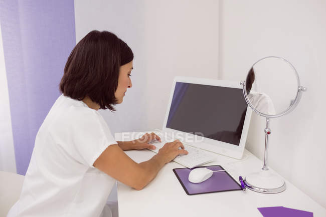 Жінка-лікар, що використовує настільний комп'ютер у клініці — стокове фото