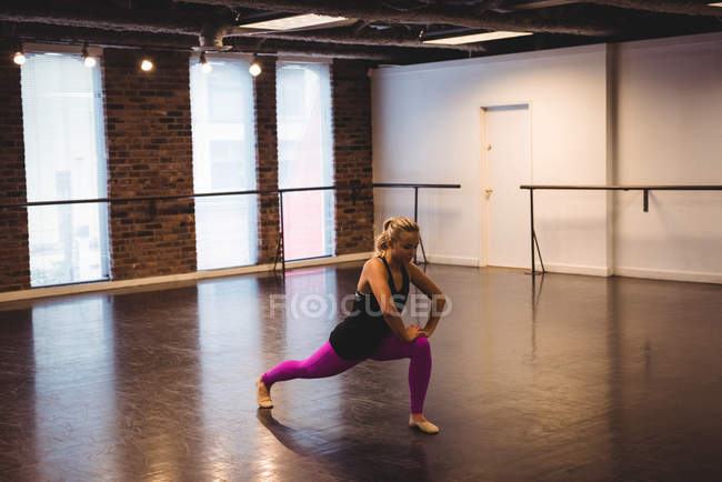 Mulher realizando exercício de alongamento no estúdio de dança — Fotografia de Stock