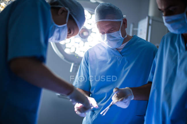Group of surgeons performing operation in operation room at hospital — Stock Photo