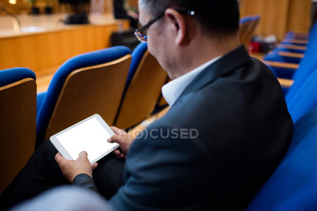 Виконавчий директор бізнесу, який бере участь у діловій зустрічі за допомогою цифрового планшета в конференц-центрі — стокове фото