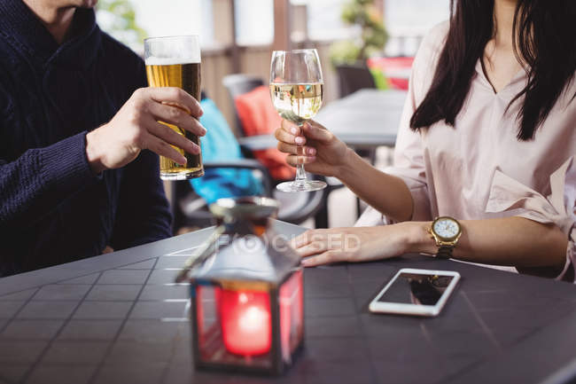 Primer plano de la pareja tomando bebidas juntos en el restaurante - foto de stock