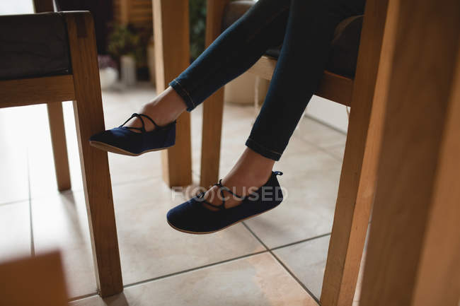 Mädchen sitzt zu Hause auf Holzstuhl — Stockfoto