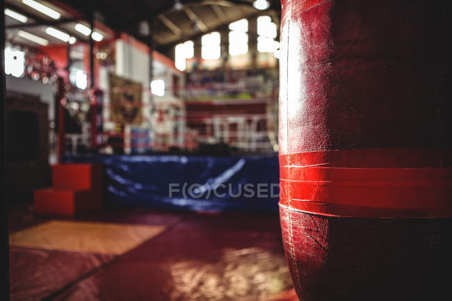 Primer plano del saco de boxeo rojo colgado en el gimnasio - foto de stock