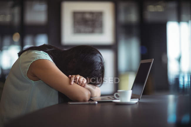 Empresária perturbada sentada em sua mesa no escritório — Fotografia de Stock