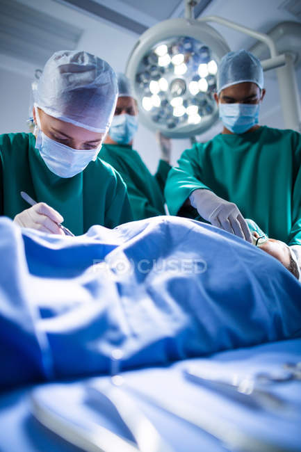 Group of surgeons performing operation in operation theater of hospital — Stock Photo