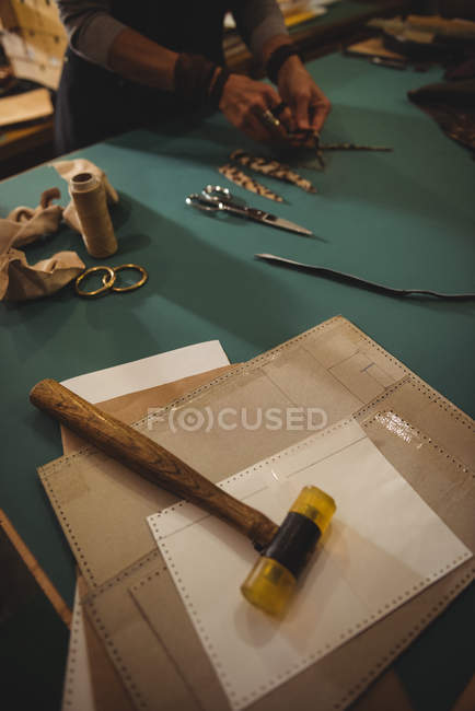 Mid-section of craftswoman working on a piece of leather in workshop — Stock Photo