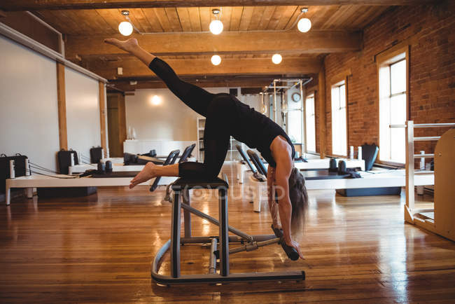 Mujer decidida practicando pilates en un gimnasio - foto de stock