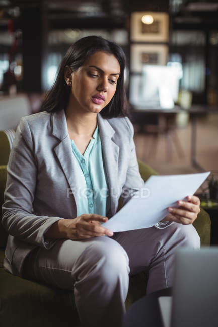 Geschäftsfrau liest Dokument im Amt — Stockfoto