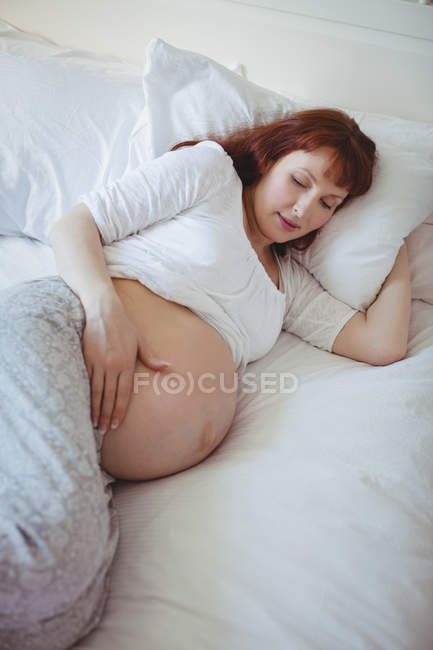 Mulher grávida relaxante na cama no quarto — Fotografia de Stock