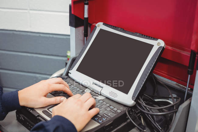 Hände einer Mechanikerin mit Laptop in Reparaturwerkstatt — Stockfoto