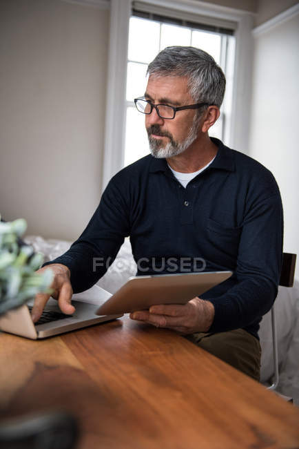 Людина, використовуючи ноутбук у вітальні на дому — стокове фото