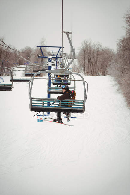 Man on ski lift going up the mountain — Stock Photo