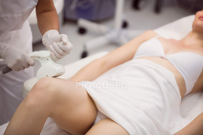 Женщина получает антицеллюлитное косметическое лечение в клинике, крупным планом — стоковое фото