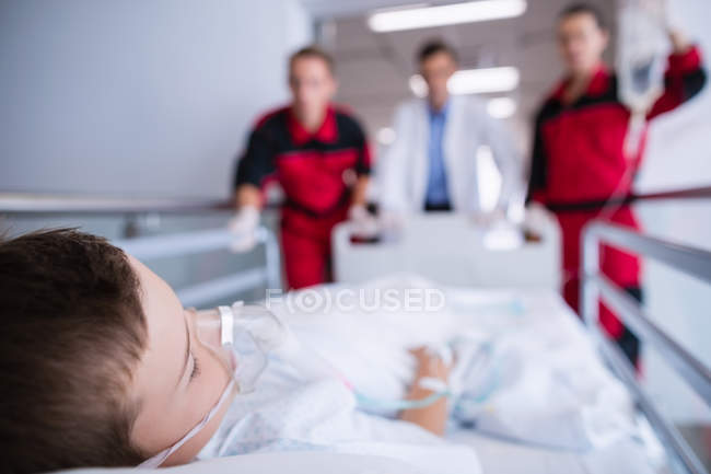 Doctors pushing emergency stretcher bed in corridor at hospital — Stock Photo