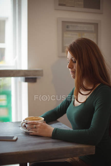 Redhead woman having coffee in the restaurant — Stock Photo