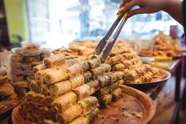 Nahaufnahme einer Verkäuferin, die türkische Süßigkeiten an der Ladentheke arrangiert — Stockfoto