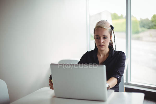 Mujer usando portátil en la cafetería - foto de stock