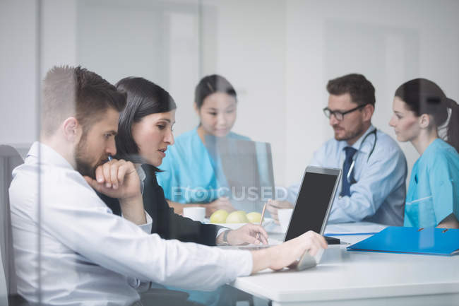 Médicos discutindo sobre laptop em reunião na sala de conferências — Fotografia de Stock