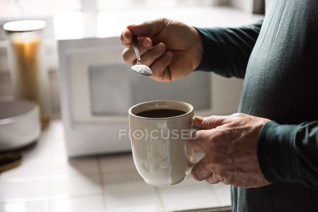 Mid-section of man preparing a black coffee in kitchen at home — Stock Photo
