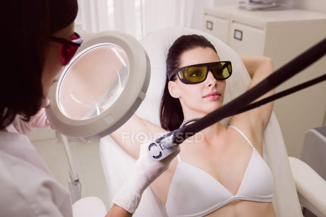 Женщина, получающая лечение лазерной эпиляции в клинике — стоковое фото