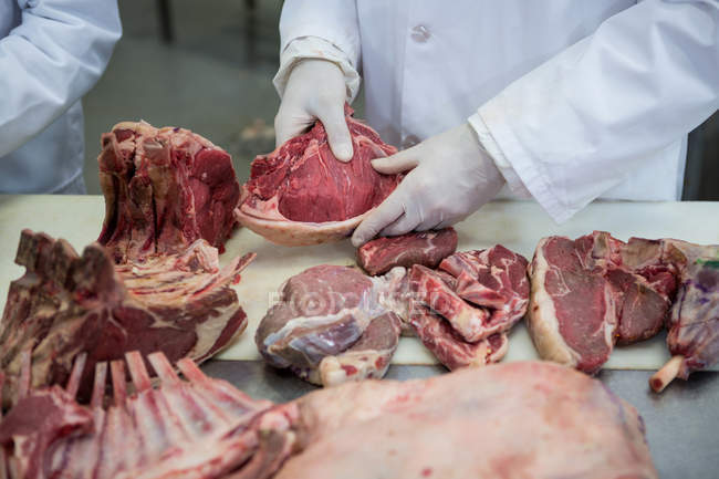 Großaufnahme von Metzger, der Fleisch in Fleischfabrik reinigt — Stockfoto