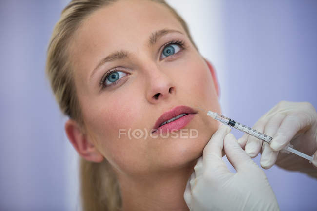 Gros plan de la patiente adulte moyenne recevant une injection de botox sur le visage — Photo de stock