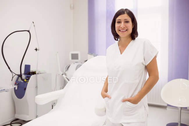 Portrait of dermatologist standing with hands in pockets in clinic — Stock Photo