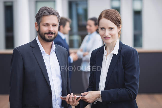 Portrait of business people holding digital tablet in office — Stock Photo