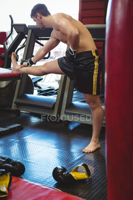 Боксер делает упражнения на растяжку в фитнес-студии — стоковое фото
