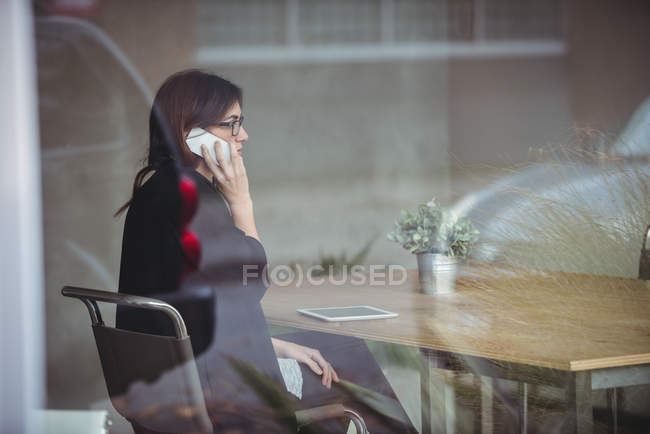 Business executive che parla al cellulare in ufficio — Foto stock
