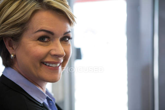 Портрет улыбающейся деловой женщины, стоящей у терминала аэропорта — стоковое фото
