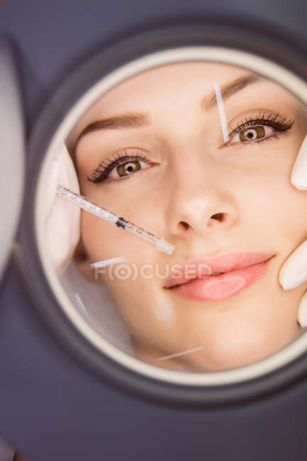Jovem paciente do sexo feminino recebendo injeção estética no rosto na clínica estética — Fotografia de Stock