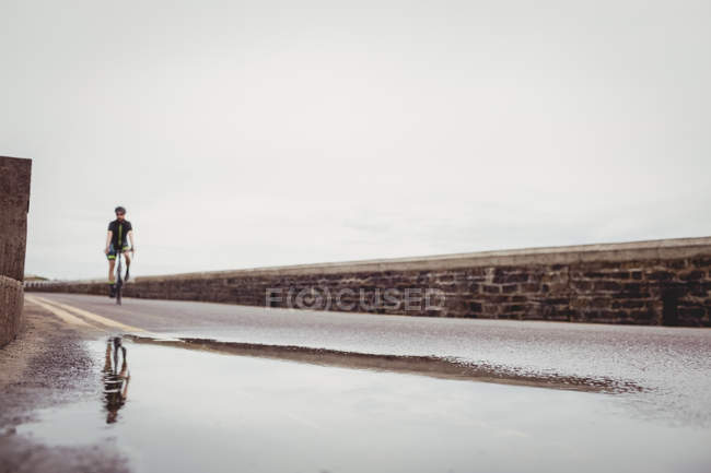 Hombre atleta montar bicicleta en el camino del campo - foto de stock